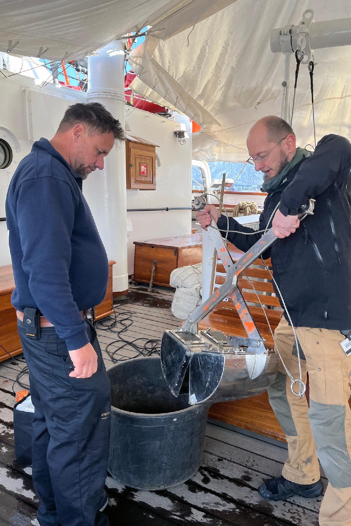 Jesper og Andreas-2.jpg To personer står på dekket til en seilbåt og tester forskningsutstyr.